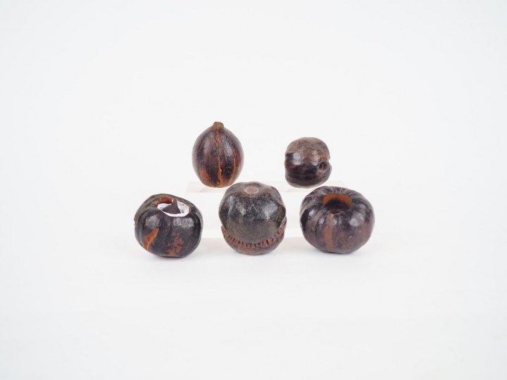 Cinq marrons d'Inde sculptés, à décor de tête de personnage.