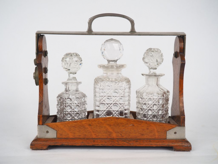 THE TANTALUS.  Cave à liqueur anglaise en bois et métal. Signée. Dim. 