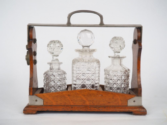 Vente aux enchères THE TANTALUS.  Cave à liqueur anglaise en bois et métal. Signée. Dim. 