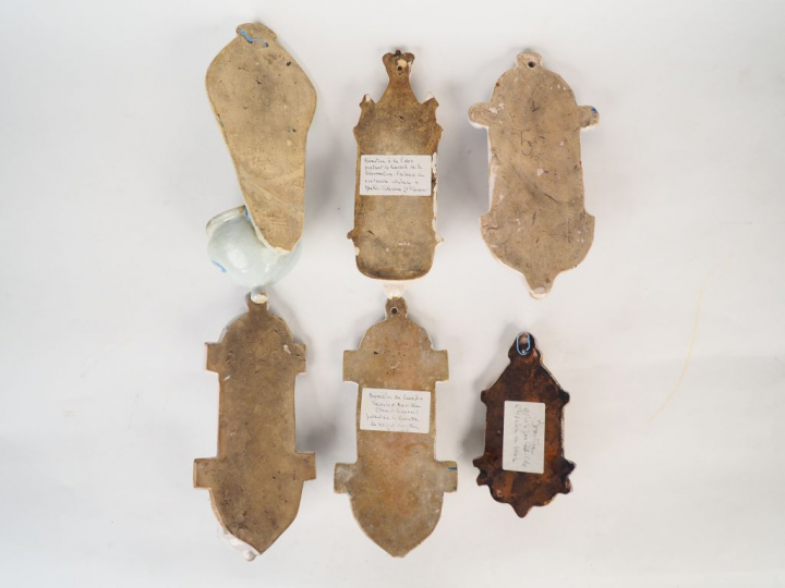 Six différents bénitiers en faïence polychrome.