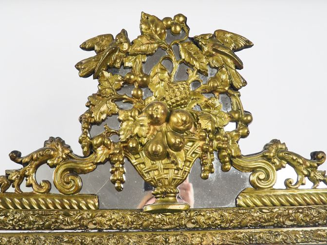 Miroir XIXème à parcloses en laiton repoussé, à décor de frise, de rin