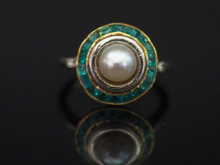 Bague en or blanc, sertie en son centre d'une perle blanche entourée d