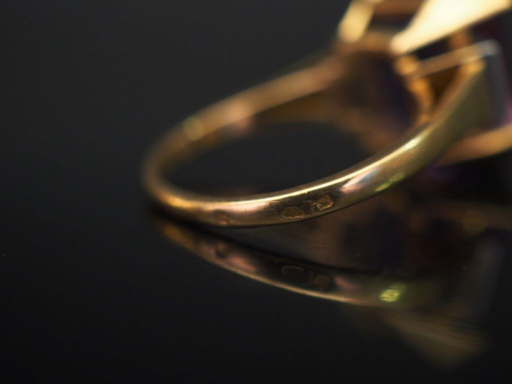 Bague en or jaune et platine, sertie en son centre d'une améthyste épa