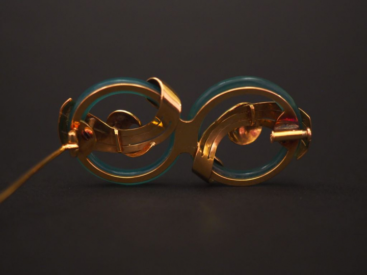 Broche en or jaune et verre, formé de deux cercles entrelacés de motif