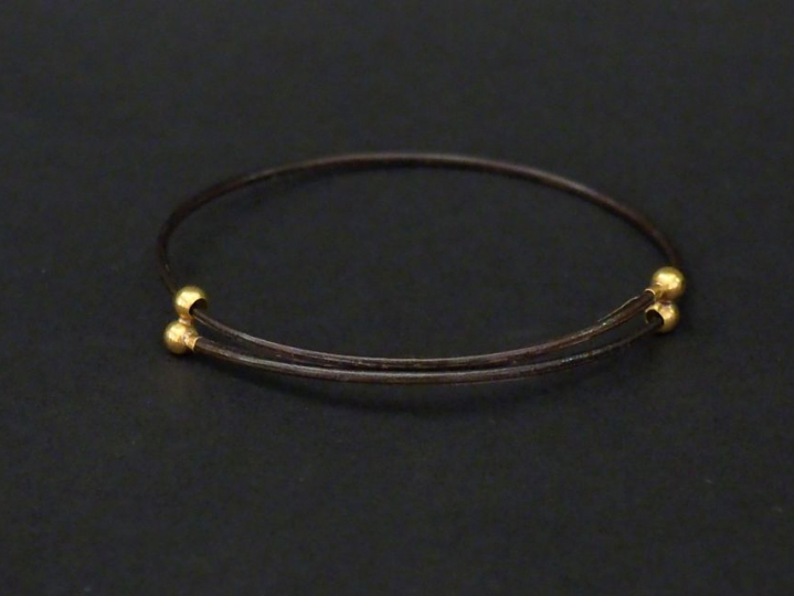 Un bracelet en poil d’éléphant et or. Poids tel. 1,29 g (petit acciden