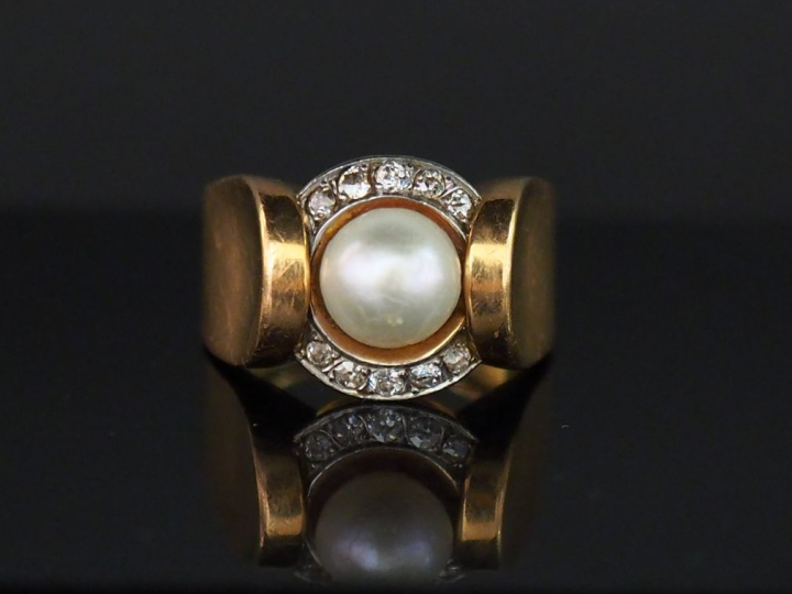 Bague en or jaune, sertie en son centre d'une perle entourée de dix pe