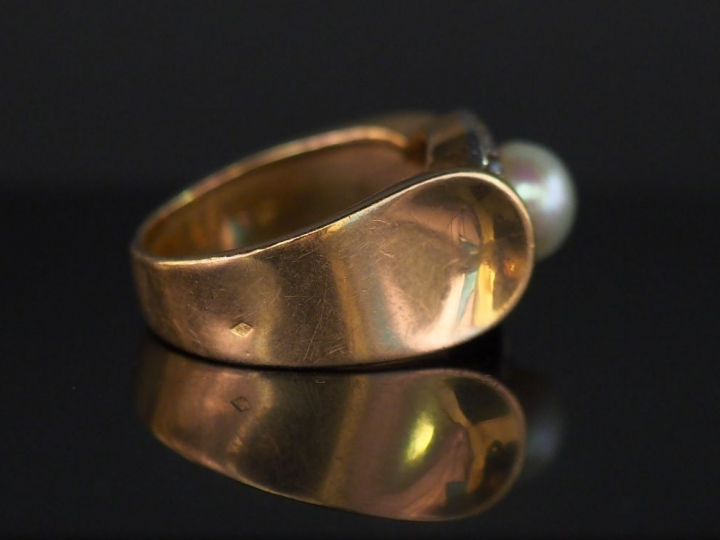 Bague en or jaune, sertie en son centre d'une perle entourée de dix pe