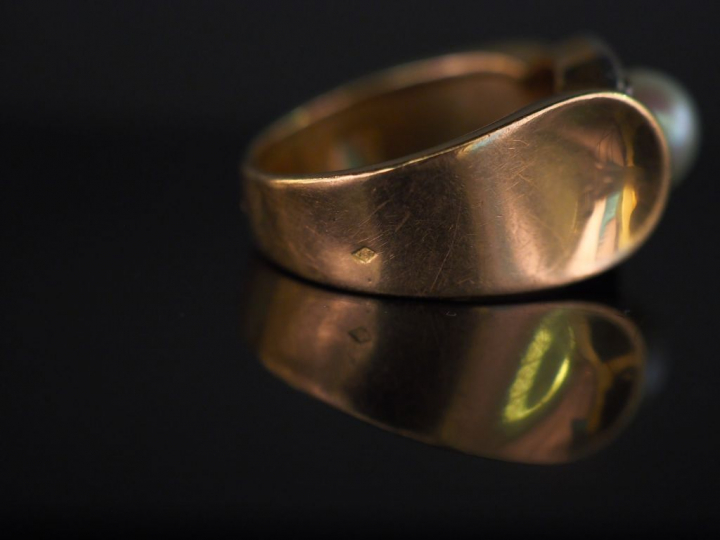 Bague en or jaune, sertie en son centre d'une perle entourée de dix pe