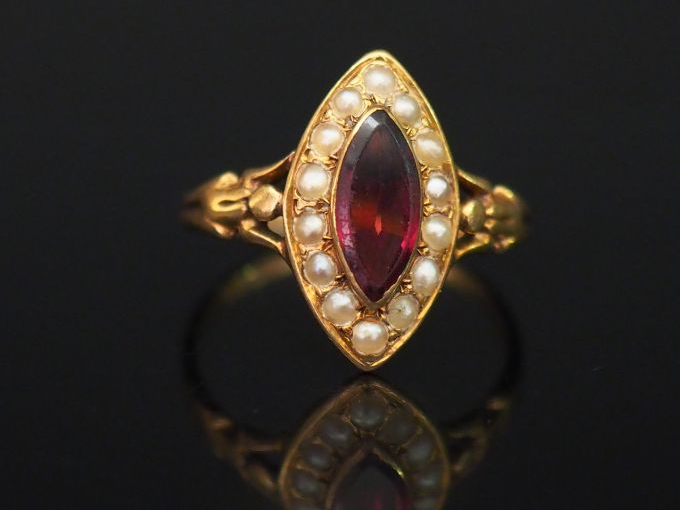 Bague Napoléon III en or jaune, sertie en son centre d'un grenat entou