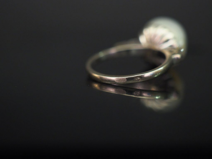 Bague en or blanc, sertie en son centre d'une perle blanche épaulée de