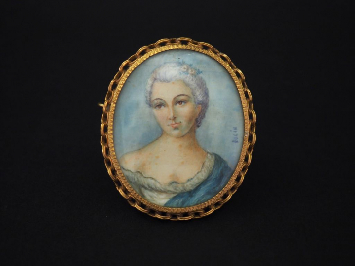 Broche ovale de style Louis XVI en or jaune, sertie en son centre d’un