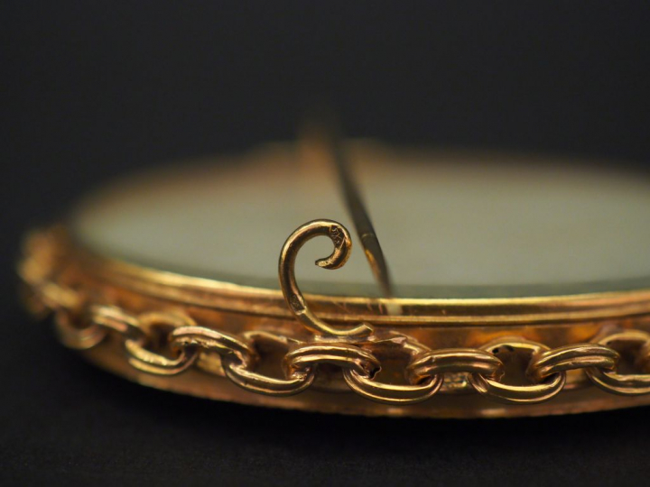 Broche ovale de style Louis XVI en or jaune, sertie en son centre d’un