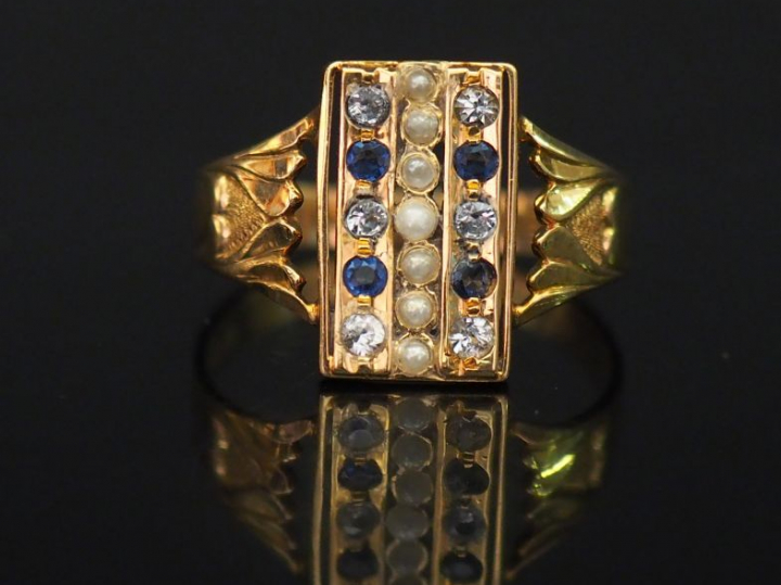 Bague en or jaune, sertie d'une ligne de perles blanches épaulée de de
