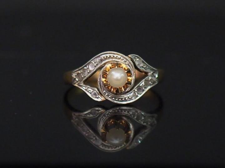 Bague en or jaune, sertie en son centre d'une perle. La monture mouvem