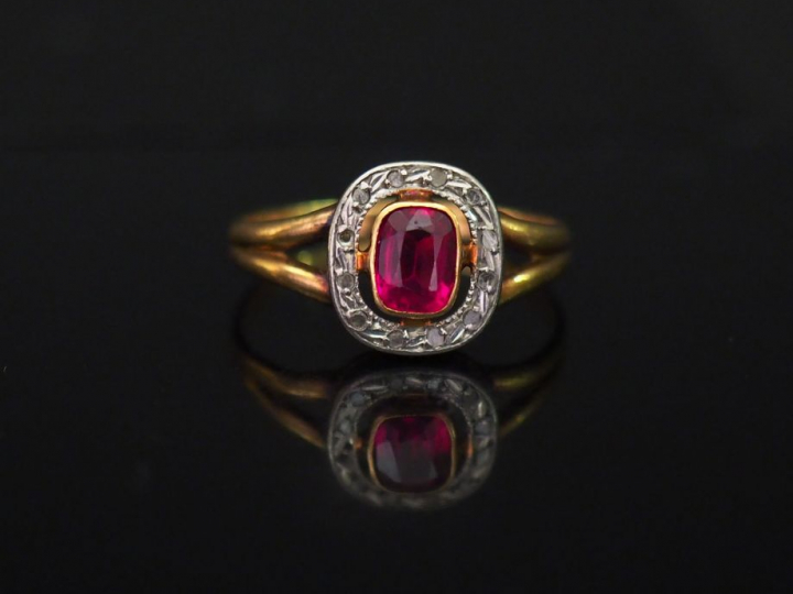 Bague en or jaune, sertie en son centre d'une pierre rose entourée d'u