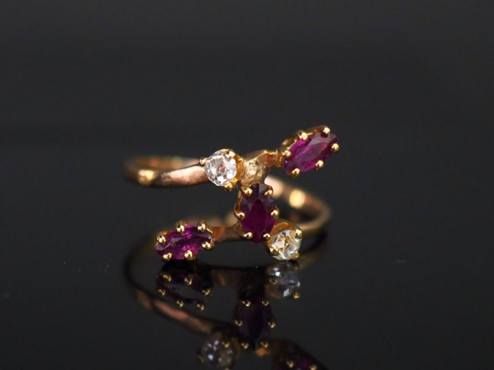 Bague de forme stylisée en or jaune, sertie de trois grenats et deux p