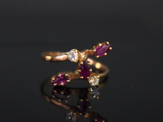 Vente aux enchères Bague de forme stylisée en or jaune, sertie de trois grenats et deux p