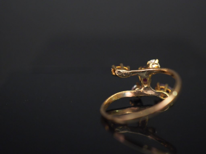 Bague de forme stylisée en or jaune, sertie de trois grenats et deux p