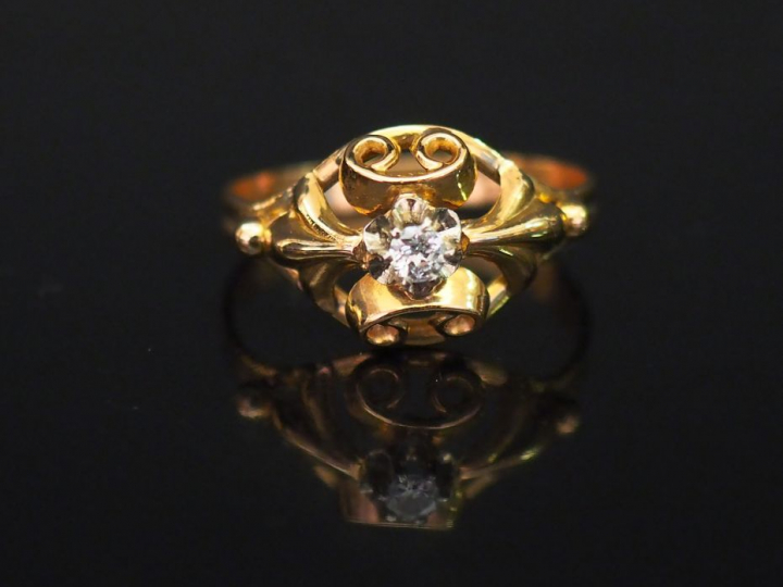 Bague ajourée en or jaune, sertie en son centre d'un petit diamant tai