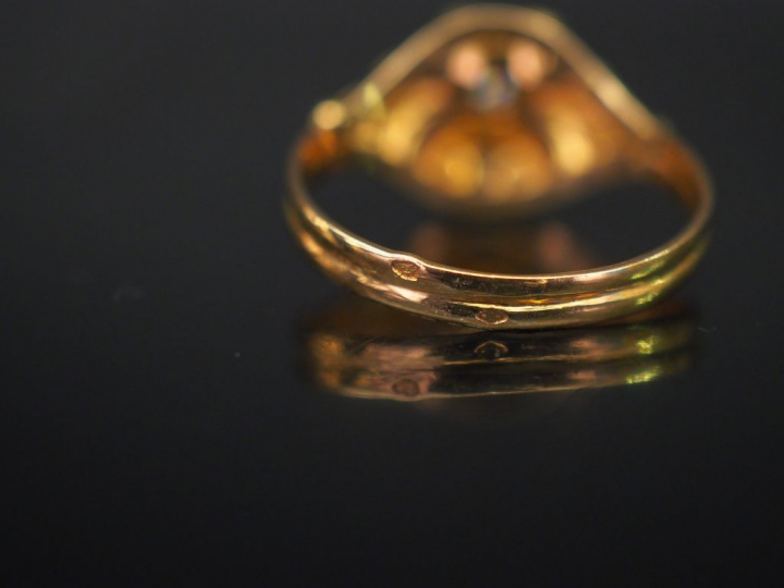 Bague ajourée en or jaune, sertie en son centre d'un petit diamant tai