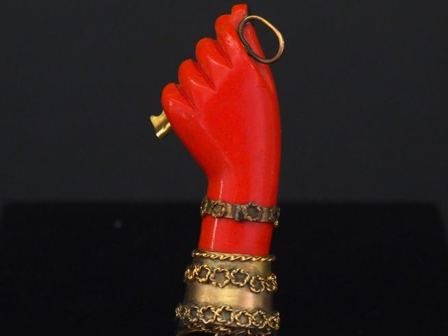 Pendentif en or jaune et composition imitant le corail, figurant une m