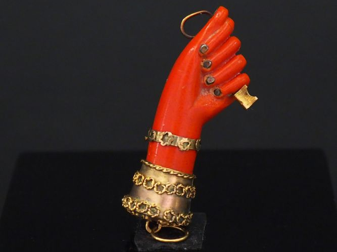 Pendentif en or jaune et composition imitant le corail, figurant une m