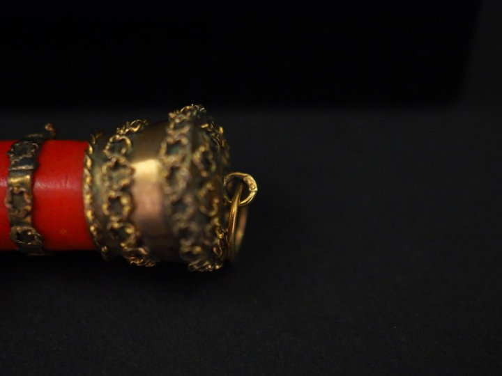 Pendentif en or jaune et composition imitant le corail, figurant une m