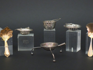 Vente aux enchères Ensemble comprenant :  - quatre différentes passettes à thé en argent,