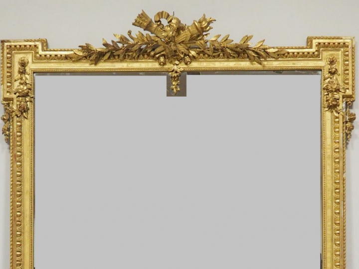 Grande glace de salon de style Louis XVI en bois et stuc doré, à décor
