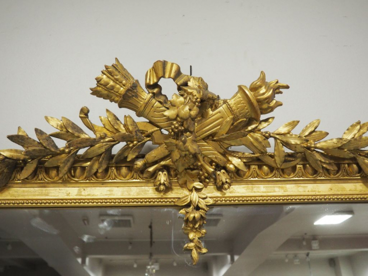 Grande glace de salon de style Louis XVI en bois et stuc doré, à décor