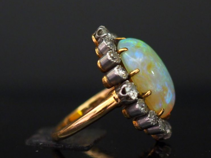 Bague en or jaune, sertie en son centre d'une opale entourée de seize 