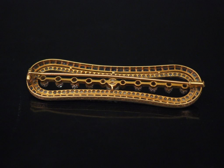 Broche barrette à bords arrondis en or jaune, sertie en son centre d'u