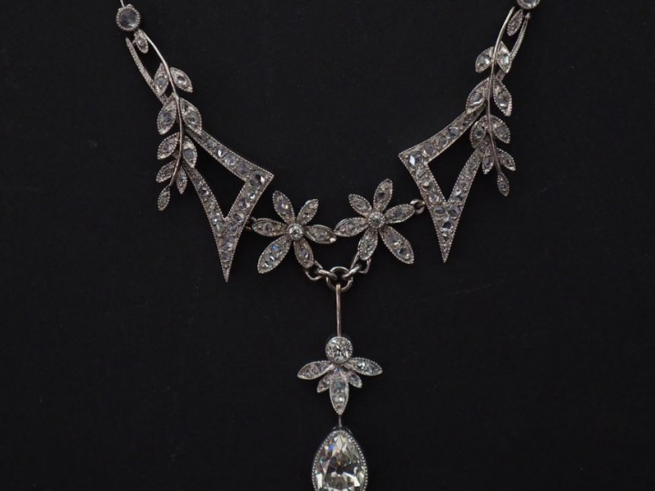 Collier articulé en en platine, à décor en son centre de fleurs et bra