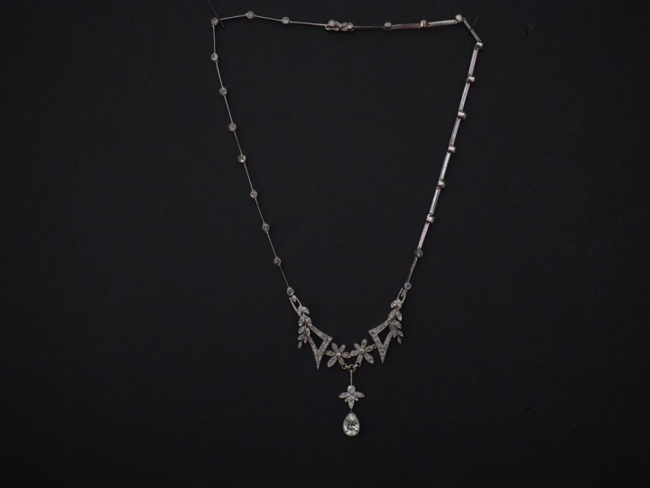 Collier articulé en en platine, à décor en son centre de fleurs et bra