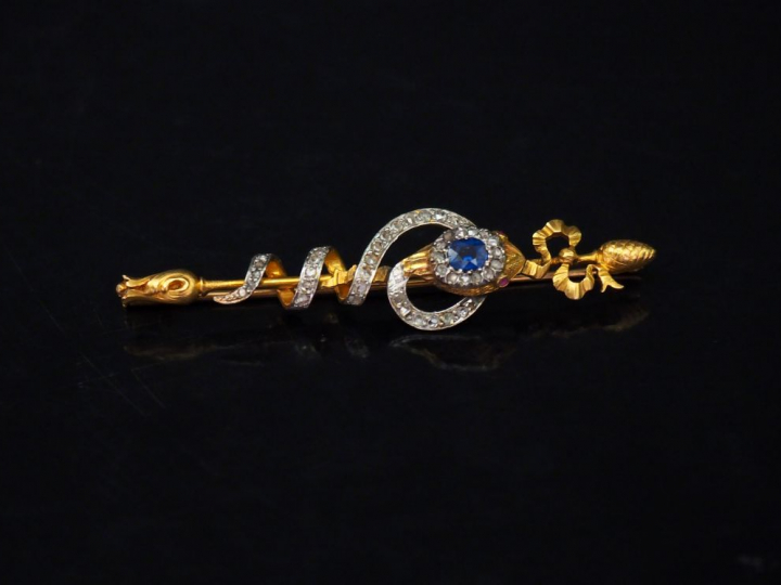 Broche barrette en or jaune, figurant un serpent entourant un axe à dé