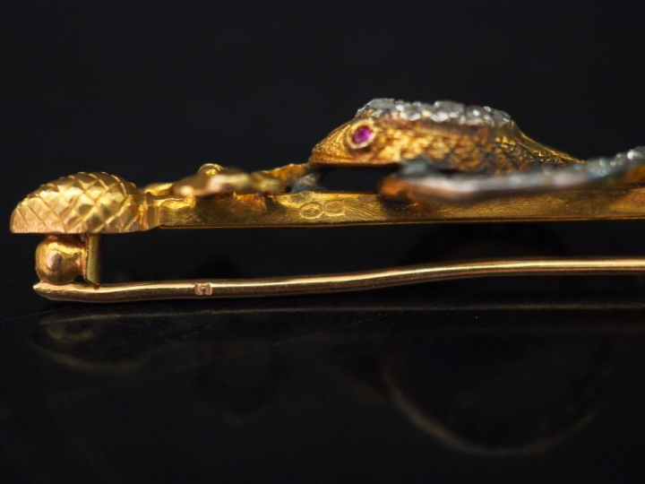 Broche barrette en or jaune, figurant un serpent entourant un axe à dé