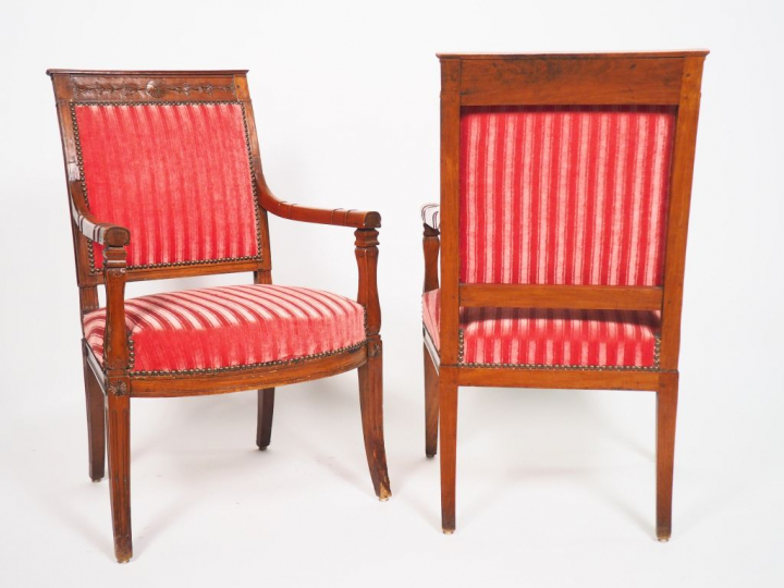 Paire de fauteuils Directoire en noyer mouluré et sculpté, à décor de 