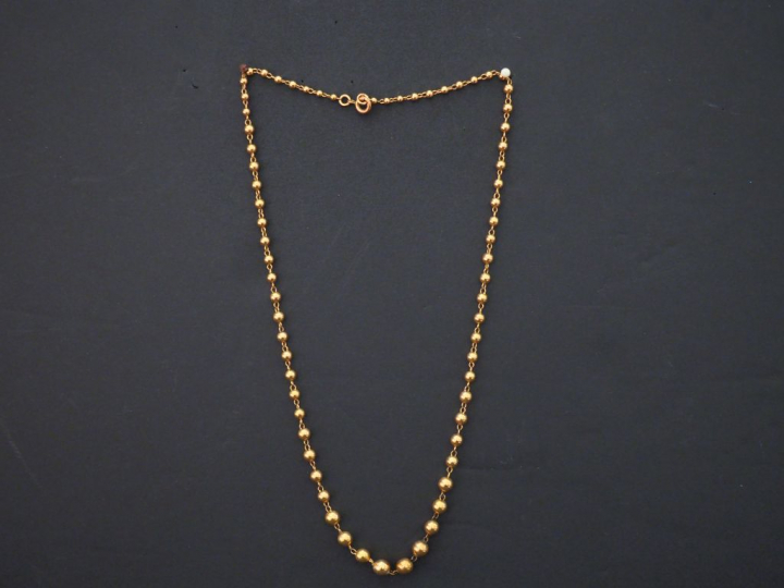 Collier souple en or jaune, à décor de boules disposées en chute. Long