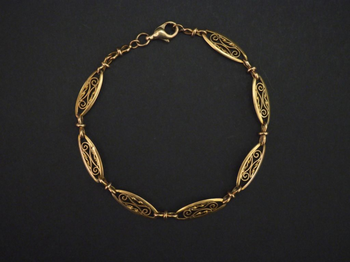 Bracelet souple en or jaune, composé de maillons ovales filigranés. Lo