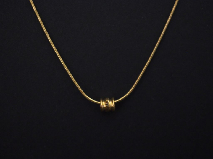 Fine chaine en or jaune, maille dite "tubogaz", à décor d'un petit pen