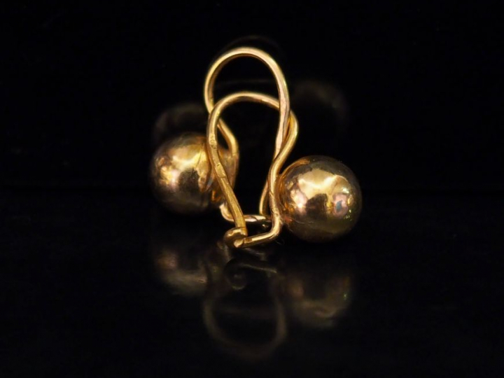 Paire de perce-oreilles en or jaune, à décor d'une boule.  H. 1,5 cm  