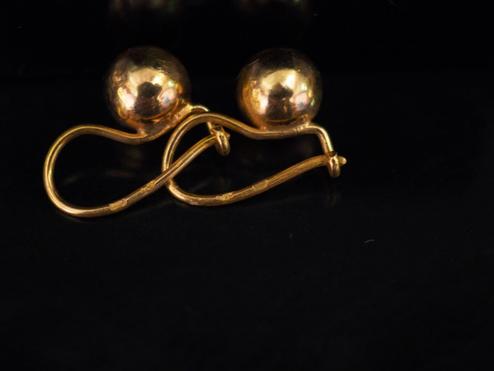Paire de perce-oreilles en or jaune, à décor d'une boule.  H. 1,5 cm  