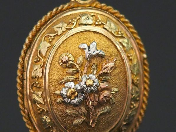 Pendentif porte-photo trois tons d'or de forme bombée, à décor en lége