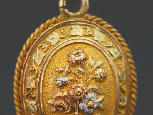 Pendentif porte-photo trois tons d'or de forme bombée, à décor en lége