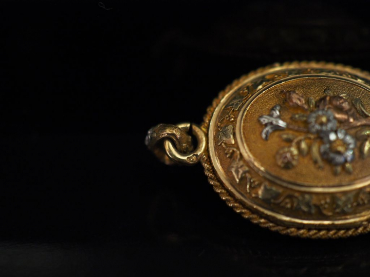 Pendentif porte-photo trois tons d'or de forme bombée, à décor en lége