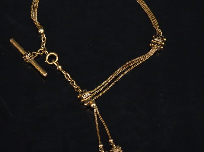 Giletière Napoléon III en or jaune, émail noir et perles, à décor de p