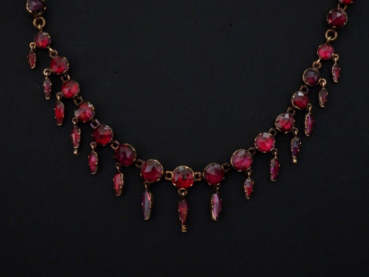 Collier draperie en or jaune et grenats disposés en chute et agrementé