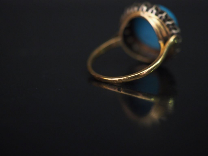 Bague en or jaune, sertie en son centre d'un turquoise en cabochon ent