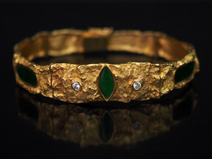 Bracelet articulé en or jaune, à décor abstrait en léger relief, serti