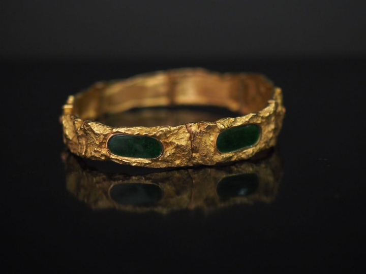 Bracelet articulé en or jaune, à décor abstrait en léger relief, serti